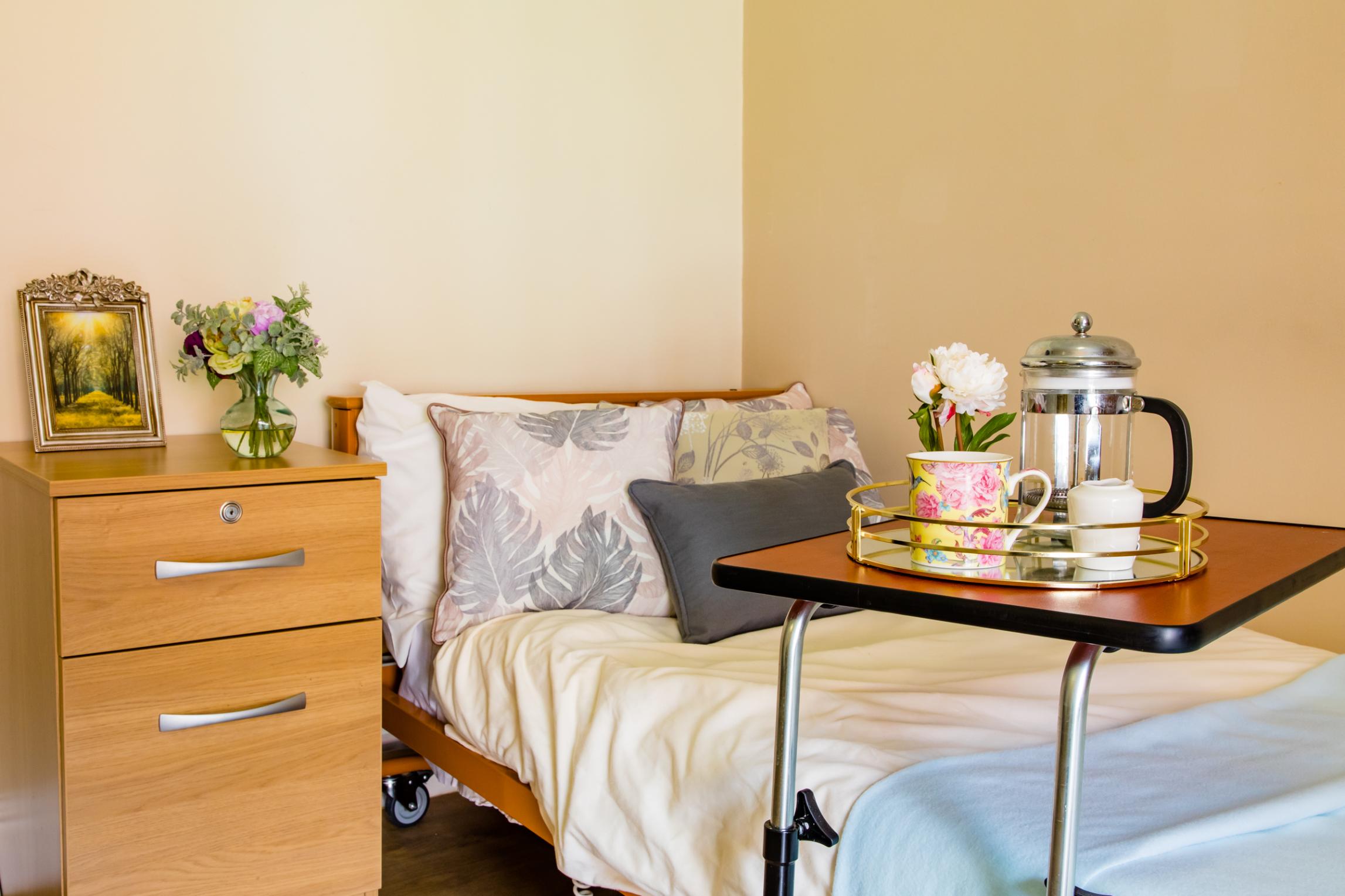 bed with cushions, tea and a side table
